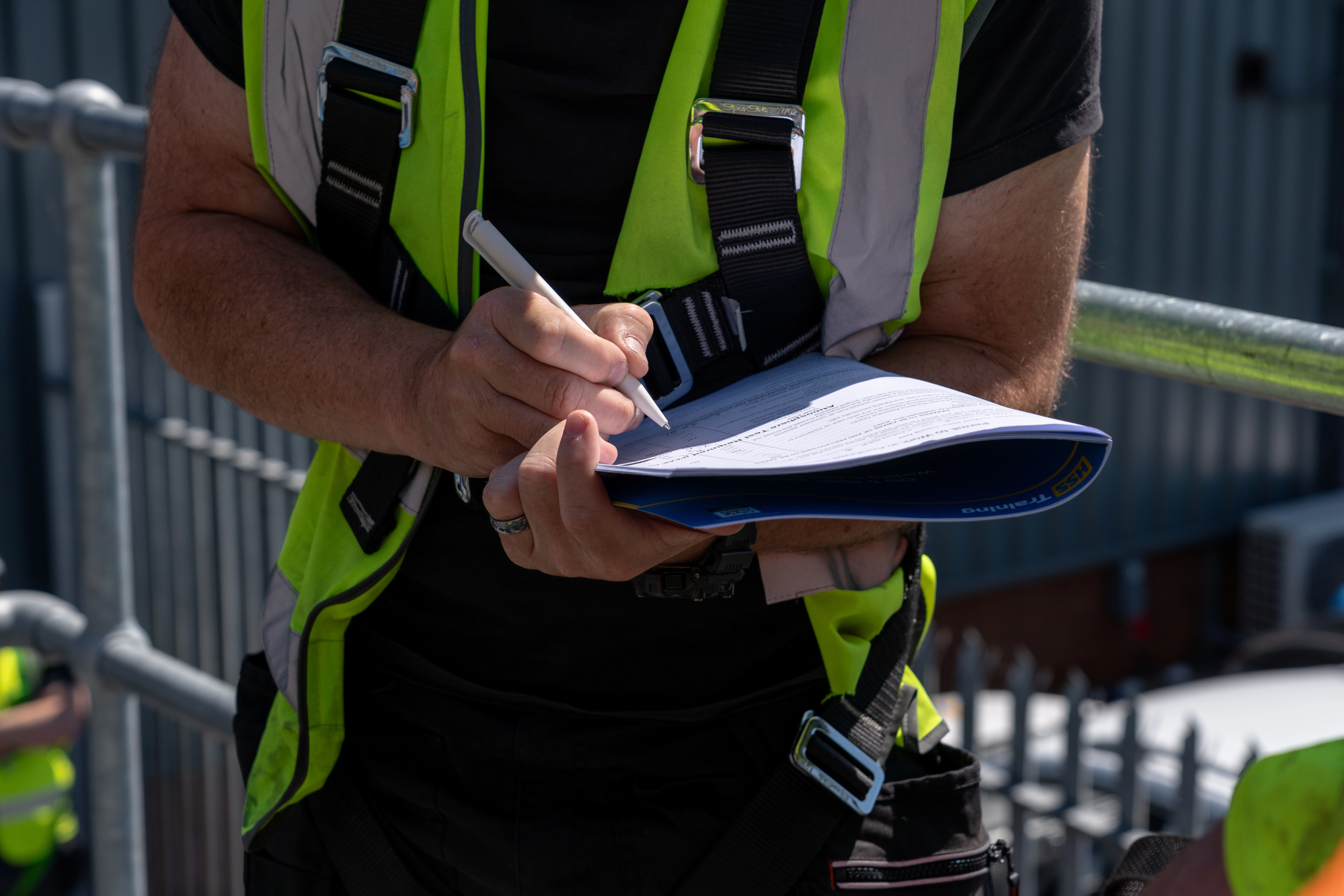 Person wearing a hi-vis jacket filling in a form 