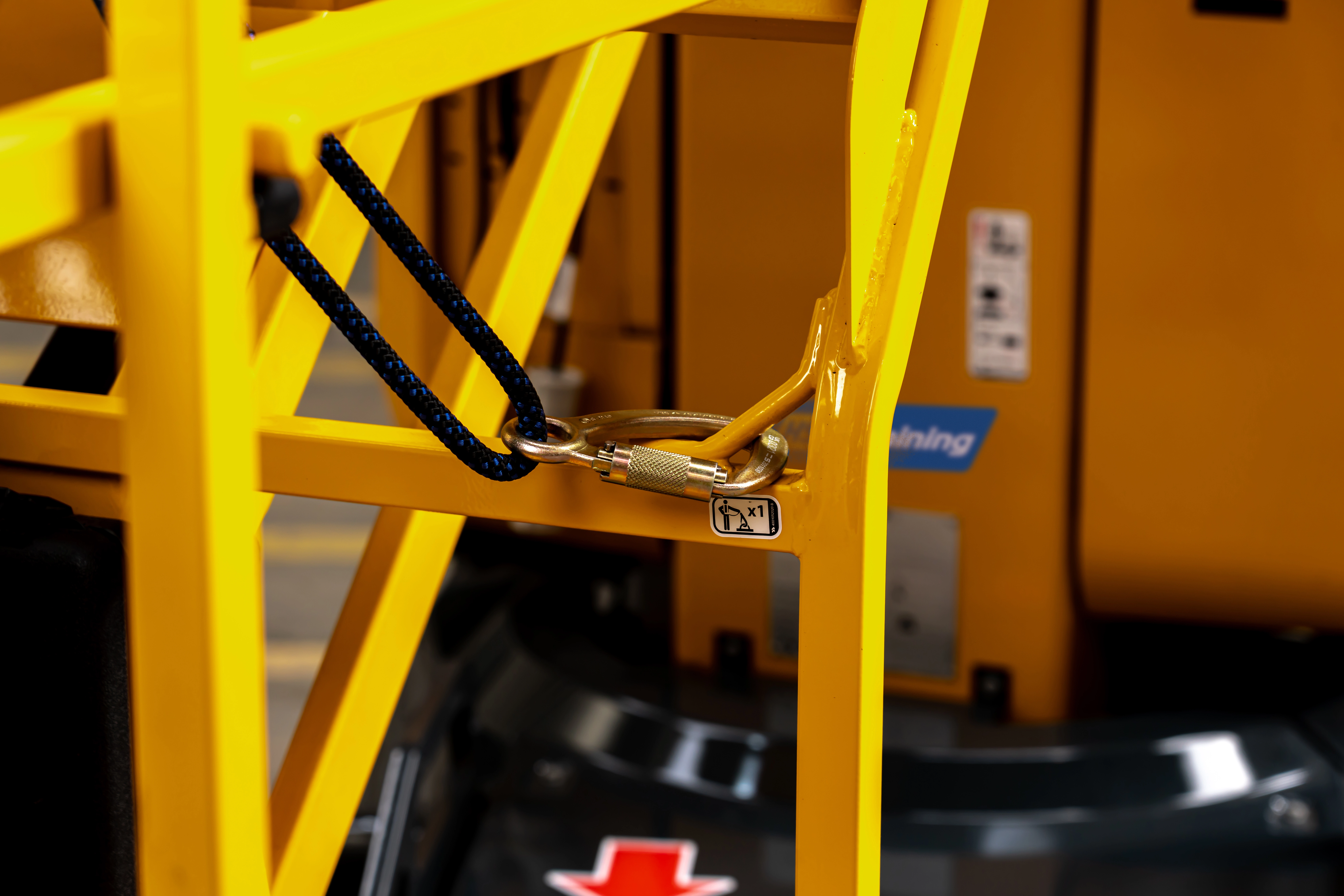Close up of a karabiner connected to a yellow MEWP cradle